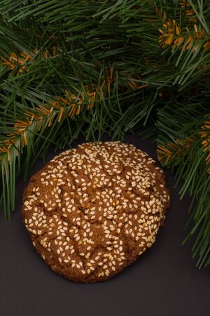Cookies with sesame seeds and fir branch on a dark backgroundの写真素材