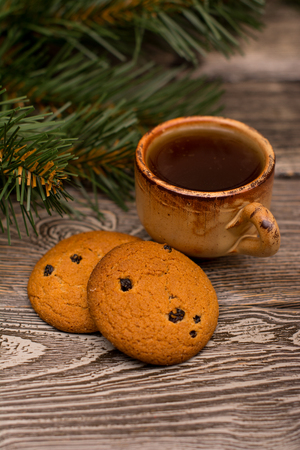 Small cup of coffee, cookies and fir branch on wooden backgroundの写真素材