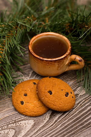 Small cup of coffee, cookies and fir branch on wooden backgroundの写真素材