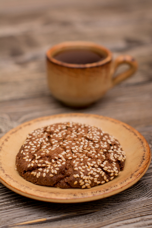 Small cup of coffee, cookies with sesame seeds on wooden backgroundの写真素材