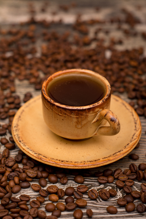 Small cup of coffee, roasted coffee beans on wooden backgroundの写真素材