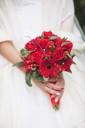 Photo wedding bouquet in hands of the brideの写真素材