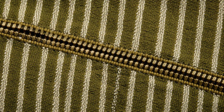 Zipper on green striped fabric, closeup. Textile backgroundの素材