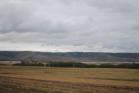 Gray sky mountain lake yellow box treesの写真素材