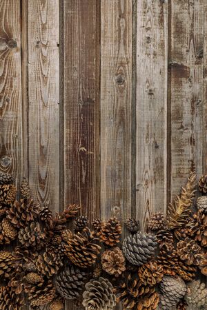 Pine cones on living room table inside a wooden bowl. Christmas decoration concept. Warm background.の写真素材