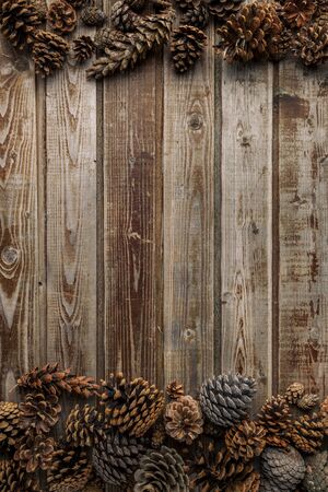 Pine cones on living room table inside a wooden bowl. Christmas decoration concept. Warm background.の写真素材
