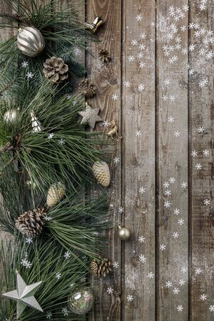 Christmas background. Spruce and pine branches with shiny balls on a wooden old vintage Board background. Christmas toy. Christmas. The view from the top. Christmas decorations.の写真素材