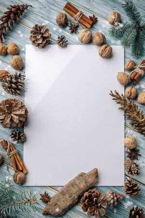 Christmas background. Spruce and pine branches on a light vintage wooden background of boards. Cones nuts spices in the decor. Christmas. The view from the top. Christmas decorations. Space for text.の写真素材