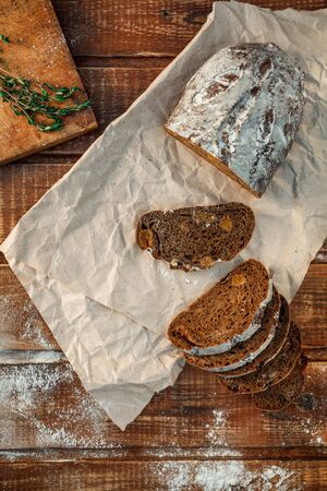 Freshly baked wheat bread, homemade cakes, still life with bread, crisp loaf of bread, still life on a rustic background, top view, rustic bread, roll, loaf. の写真素材