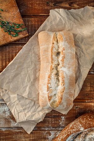 Freshly baked wheat bread, homemade cakes, still life with bread, crisp loaf of bread, still life on a rustic background, top view, rustic bread, roll, loaf. の写真素材