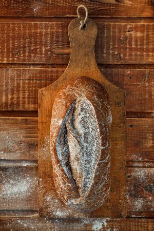 Freshly baked wheat bread, homemade cakes, still life with bread, crisp loaf of bread, still life on a rustic background, top view, rustic bread, roll, loaf. の写真素材