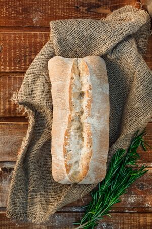 Freshly baked wheat bread, homemade cakes, still life with bread, crisp loaf of bread, still life on a rustic background, top view, rustic bread, roll, loaf. の写真素材