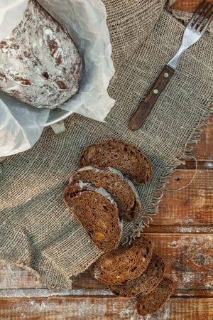 Freshly baked wheat bread, homemade cakes, still life with bread, crisp loaf of bread, still life on a rustic background, top view, rustic bread, roll, loaf. の写真素材