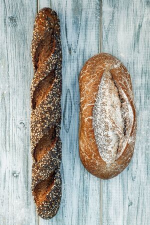 Freshly baked wheat bread, homemade cakes, still life with bread, crisp loaf of bread, still life on a rustic background, top view, rustic bread, roll, loaf. の写真素材