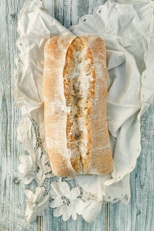 Freshly baked wheat bread, homemade cakes, still life with bread, crisp loaf of bread, still life on a rustic background, top view, rustic bread, roll, loaf. の写真素材