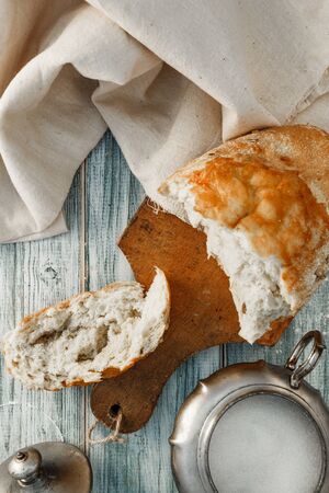 Freshly baked wheat bread, homemade cakes, still life with bread, crisp loaf of bread, still life on a rustic background, top view, rustic bread, roll, loaf. の写真素材