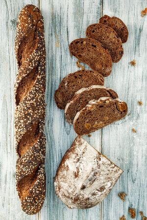 Freshly baked wheat bread, homemade cakes, still life with bread, crisp loaf of bread, still life on a rustic background, top view, rustic bread, roll, loaf. の写真素材