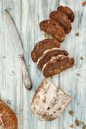 Freshly baked wheat bread, homemade cakes, still life with bread, crisp loaf of bread, still life on a rustic background, top view, rustic bread, roll, loaf. の写真素材