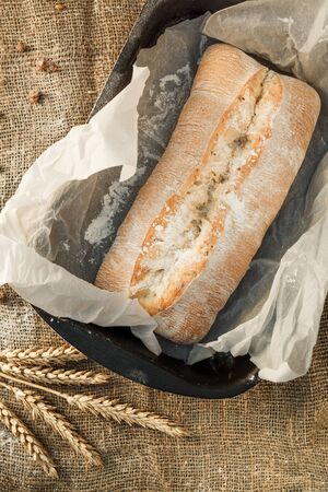 Freshly baked wheat bread, homemade cakes, still life with bread, crisp loaf of bread, still life on a rustic background, top view, rustic bread, roll, loaf.の写真素材