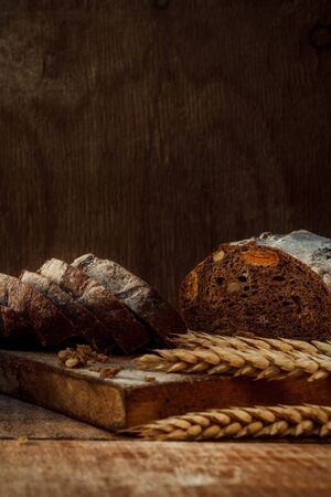 Freshly baked wheat bread, homemade cakes, still life with bread, crisp loaf of bread, still life on a rustic background, top view, rustic bread, roll, loaf.の写真素材