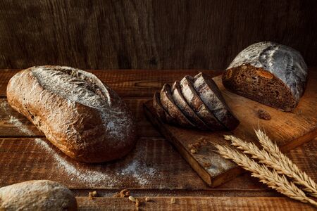 Freshly baked wheat bread, homemade cakes, still life with bread, crisp loaf of bread, still life on a rustic background, top view, rustic bread, roll, loaf.の写真素材