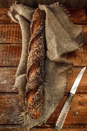 Freshly baked wheat bread, homemade cakes, still life with bread, crisp loaf of bread, still life on a rustic background, top view, rustic bread, roll, loaf. の写真素材