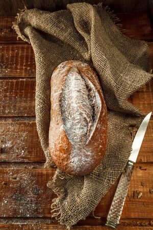 Freshly baked wheat bread, homemade cakes, still life with bread, crisp loaf of bread, still life on a rustic background, top view, rustic bread, roll, loaf. の写真素材
