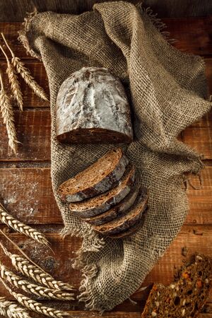 Freshly baked wheat bread, homemade cakes, still life with bread, crisp loaf of bread, still life on a rustic background, top view, rustic bread, roll, loaf. の写真素材