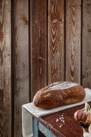 Freshly baked wheat bread, homemade cakes, still life with bread, crisp loaf of bread, still life on a rustic background, top view, rustic bread, roll, loaf.の写真素材