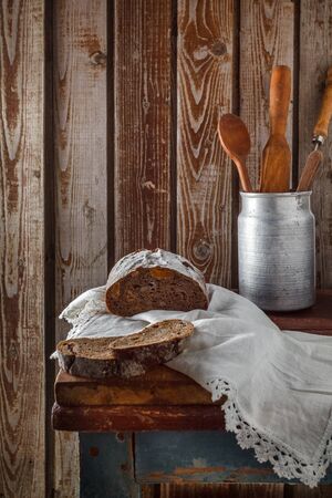 Freshly baked wheat bread, homemade cakes, still life with bread, crisp loaf of bread, still life on a rustic background, top view, rustic bread, roll, loaf.の写真素材