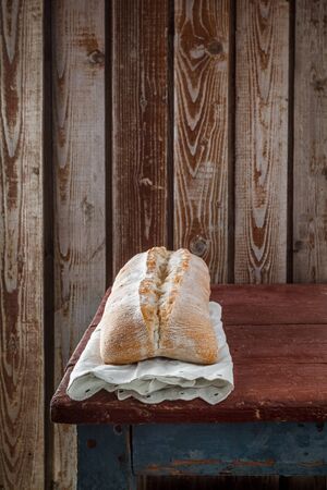 Freshly baked wheat bread, homemade cakes, still life with bread, crisp loaf of bread, still life on a rustic background, top view, rustic bread, roll, loaf.の写真素材