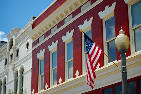 Colorful old downtown buildings with American flag and lamp postの写真素材