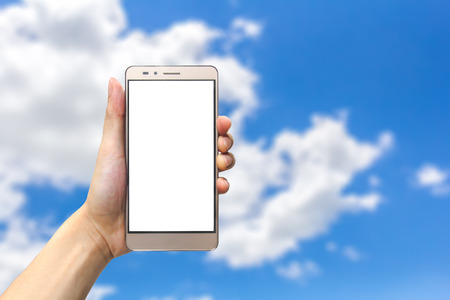 hand holding smartphone with blank screen on bluesky backgroundの写真素材