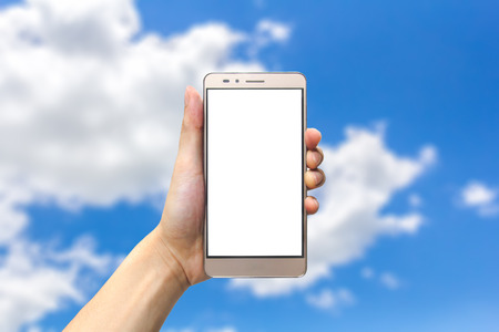 hand holding smartphone with blank screen on bluesky backgroundの写真素材