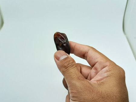 Dates fruit in hand isolated on white background. Selective focus.の写真素材