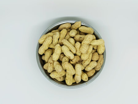 Peanuts in a bowl on white background. Close-up.