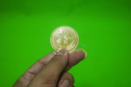 Bitcoin. Golden bitcoin isolated on green backgroundの写真素材