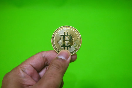 Bitcoin. Golden bitcoin isolated on green backgroundの写真素材