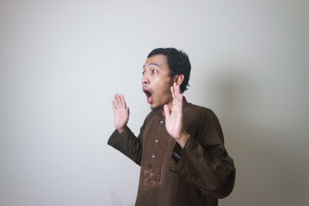 Moslem Asian man surprised expression looking to camera when Ramadan celebration. The photo is...