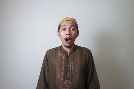 Moslem Asian man surprised expression looking to camera when Ramadan celebration. The photo is...