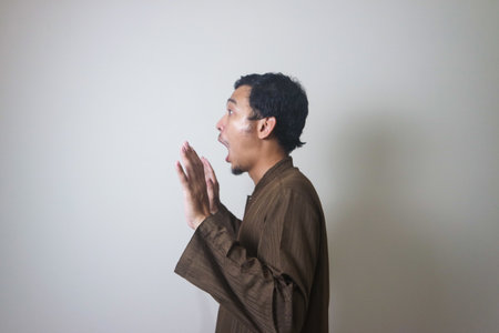 Moslem Asian man surprised expression looking to camera when Ramadan celebration. The photo is...