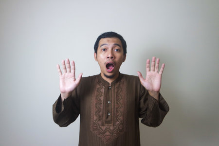 Moslem Asian man surprised expression looking to camera when Ramadan celebration. The photo is...