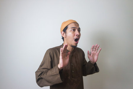 Moslem Asian man surprised expression looking to camera when Ramadan celebration. The photo is...