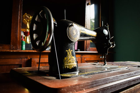 Tuban, Indonesia - September 7, 2023: An antique Butterfly Sewing Machine on the wooden desk. Vintage, Old, Retro Sewing Machineのeditorial素材