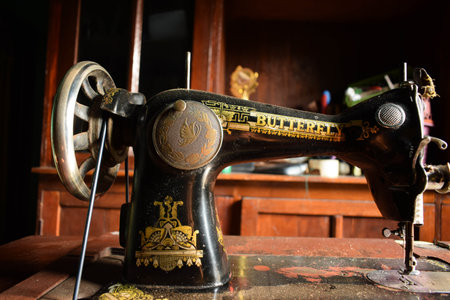 Tuban, Indonesia - September 7, 2023: An antique Butterfly Sewing Machine on the wooden desk....