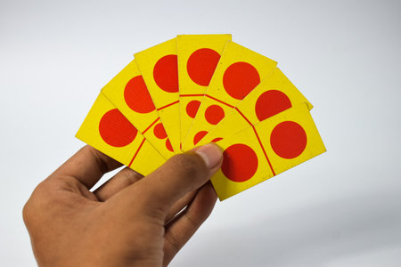 hand hold dominoes playing cards isolated white background, yellow red dominoes cardsの写真素材