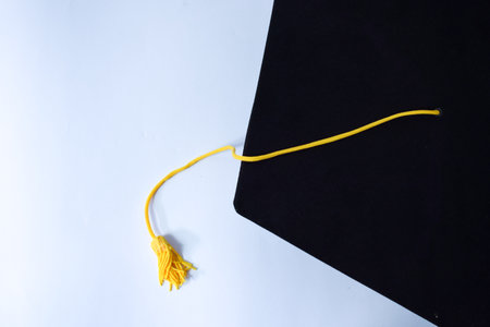 Close-up Black Graduation Hat and Yellow Tassel isolated on white background