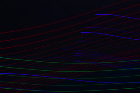 Long exposure colorful abstract line painting background isolated on black. curvy lines from led...