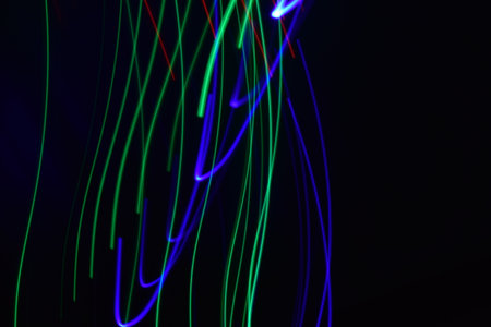 Long exposure colorful abstract line painting background isolated on black. curvy lines from led...