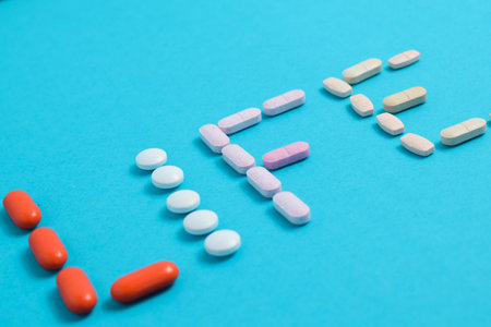 Life word from Colorful Medicine Pills isolated on blue background, supplement, vitamin, colorful